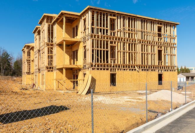 a temporary chain link fence in front of a building under construction, ensuring public safety in Baytown, TX